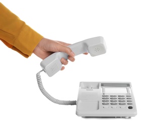 Young woman picking up telephone on white background