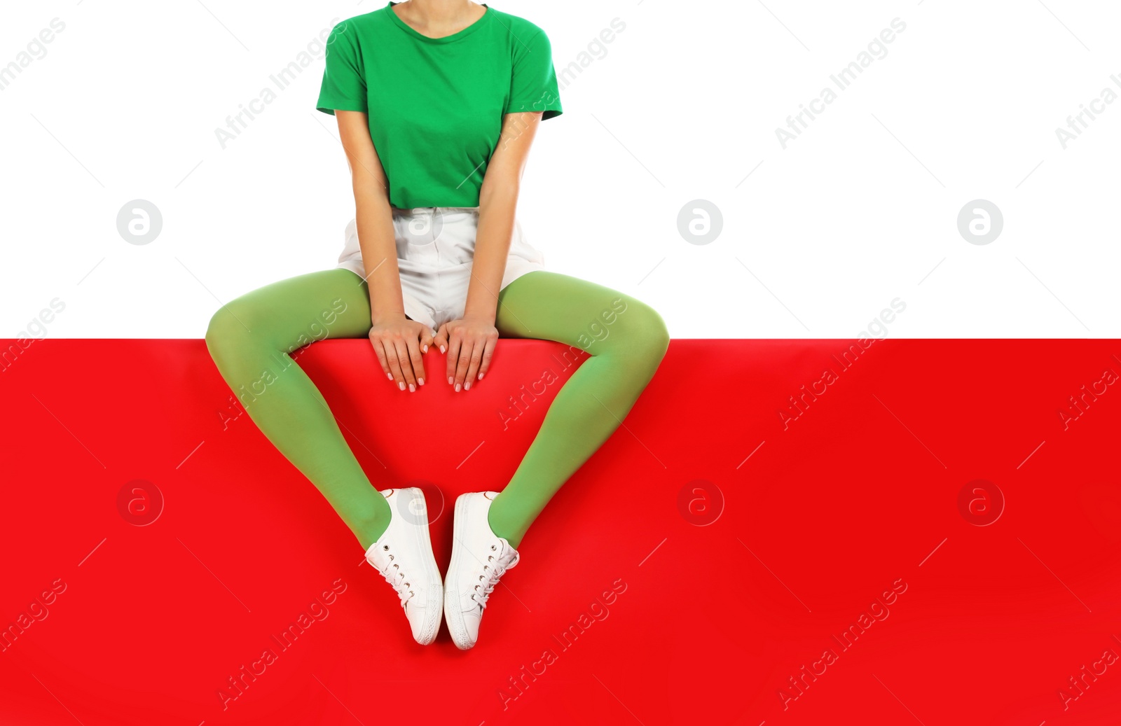 Photo of Woman wearing green tights sitting on color background, closeup. Space for text