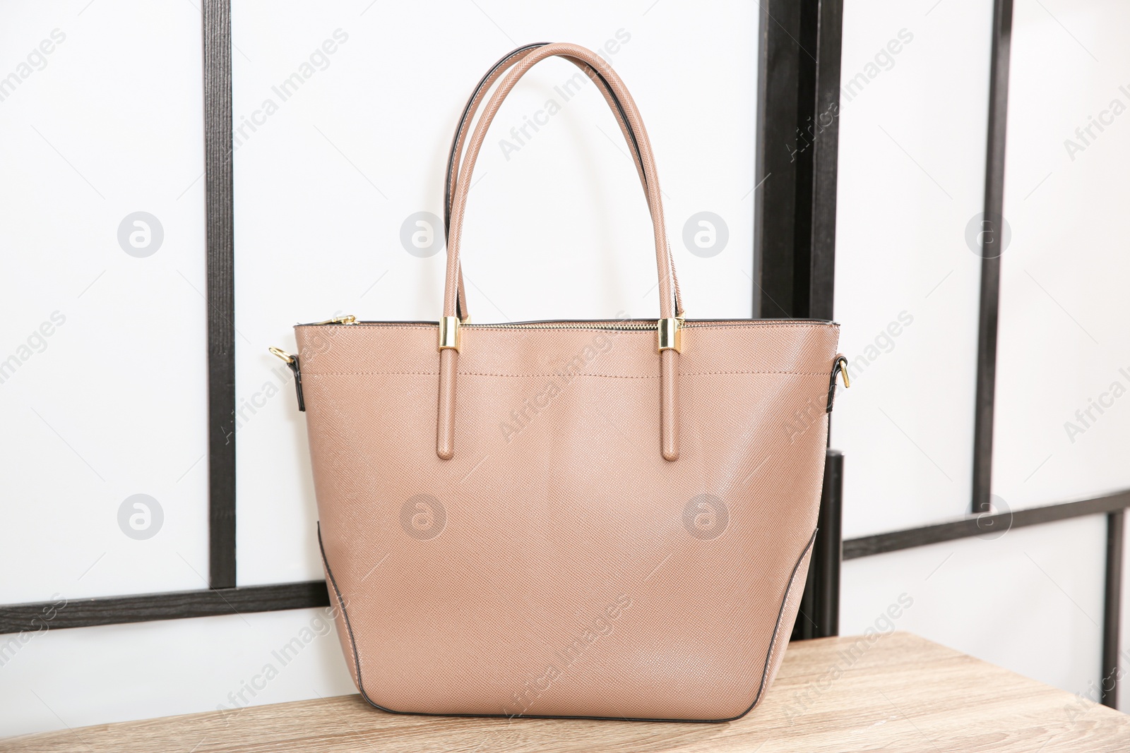 Photo of Beige woman's bag on wooden shelf in store