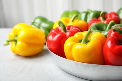 Dish with ripe paprika peppers on table