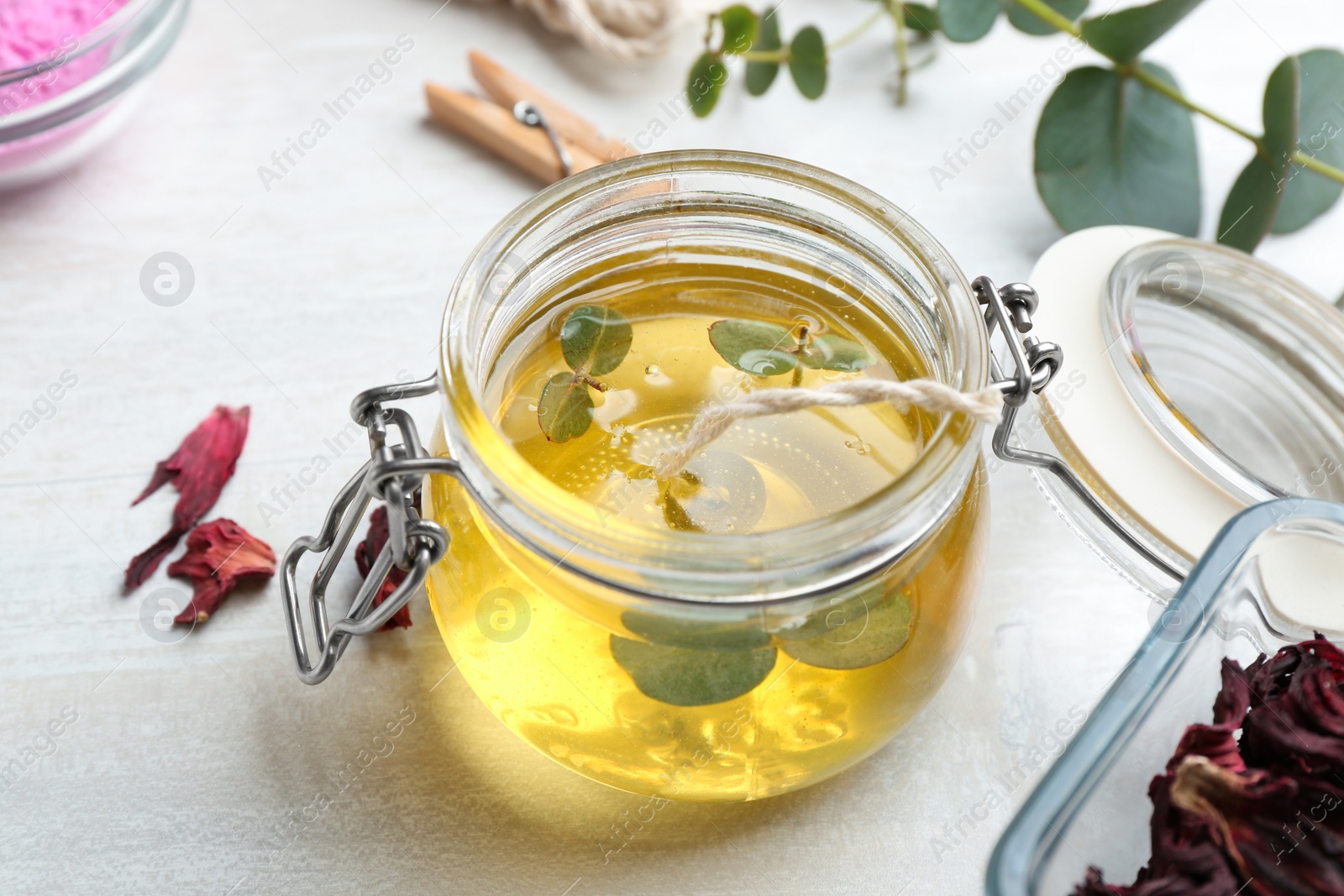 Photo of Aromatic homemade candle in glass jar on light table