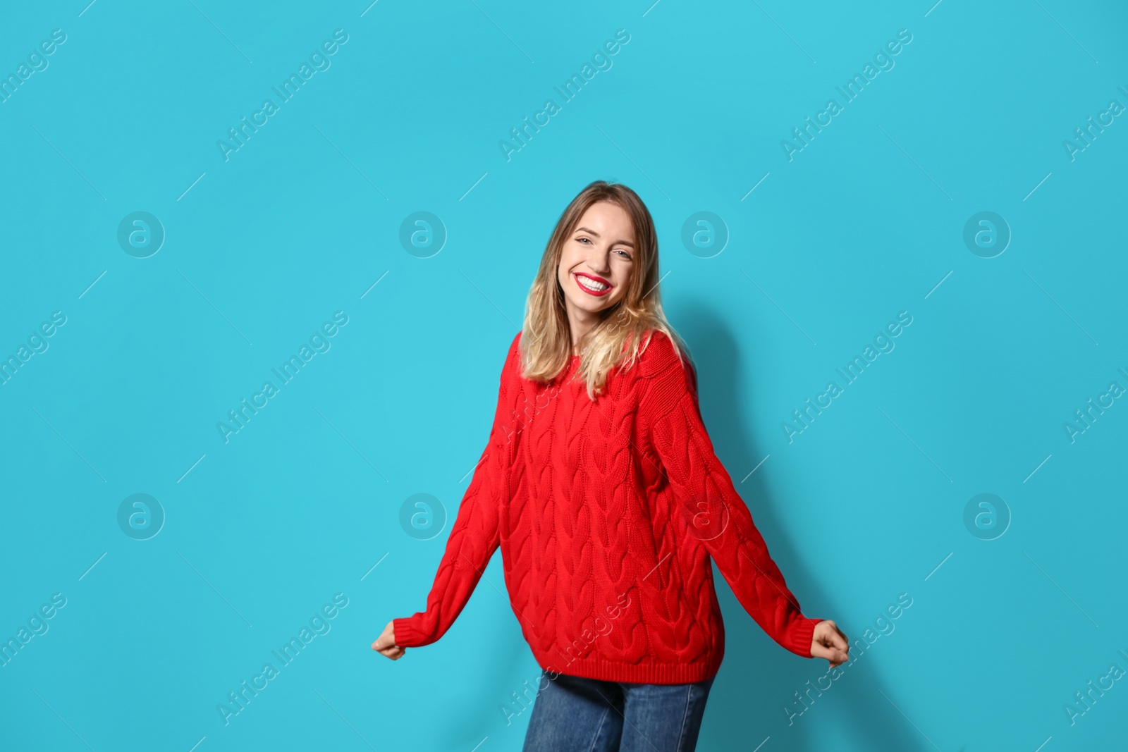 Photo of Beautiful young woman in warm sweater on color background