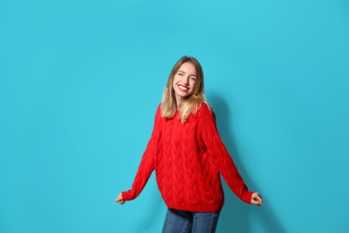 Photo of Beautiful young woman in warm sweater on color background