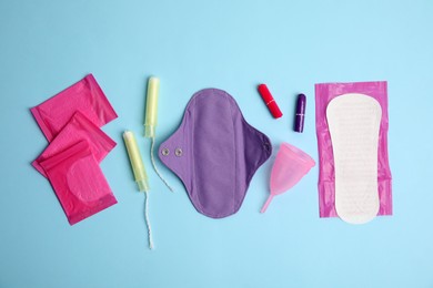 Tampons and other menstrual hygienic products on light blue background, flat lay