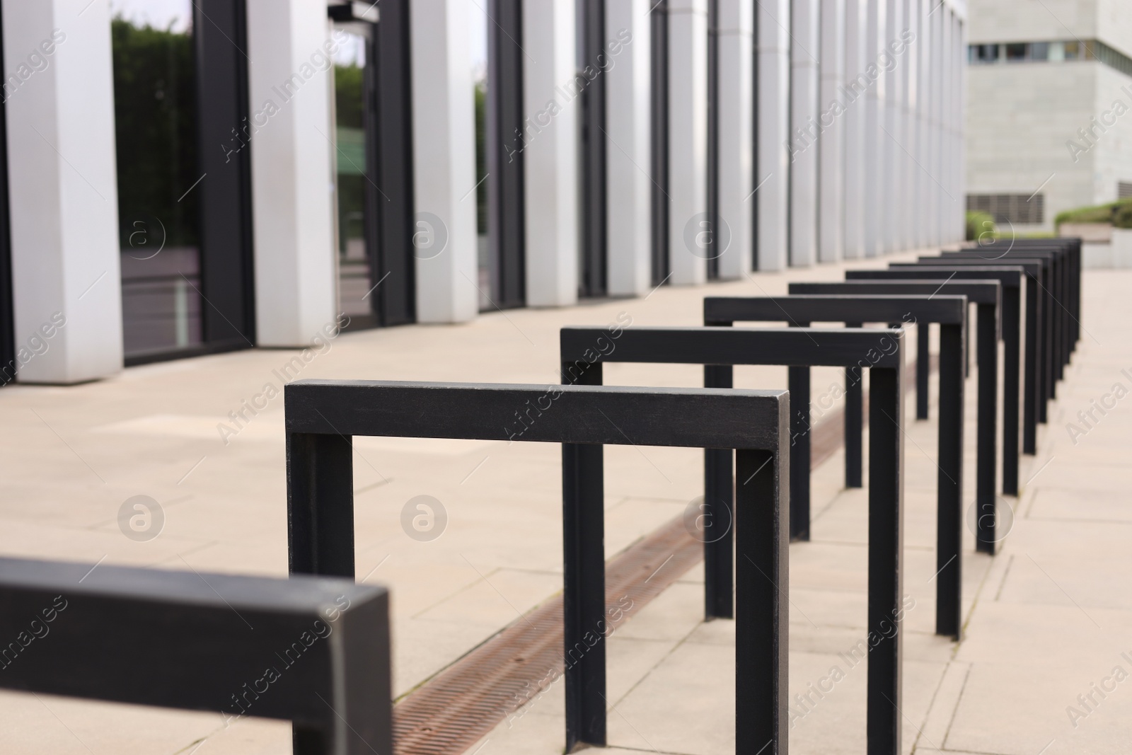 Photo of Empty bicycle stands near building on city street