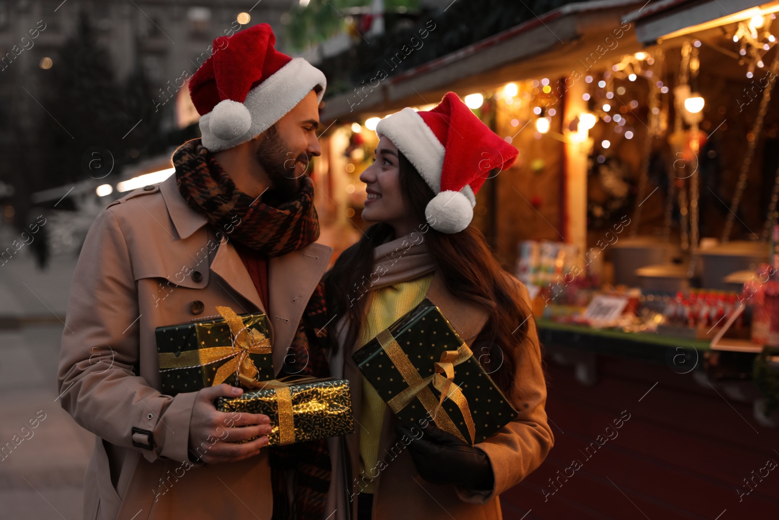 Photo of Lovely couple with Christmas presents at winter fair