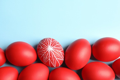 Photo of Flat lay composition of painted red Easter eggs on color background, space for text