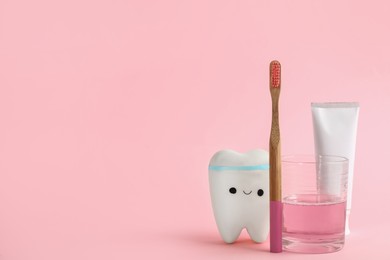 Photo of Mouthwash, toothbrush, paste and holder on pink background. Space for text
