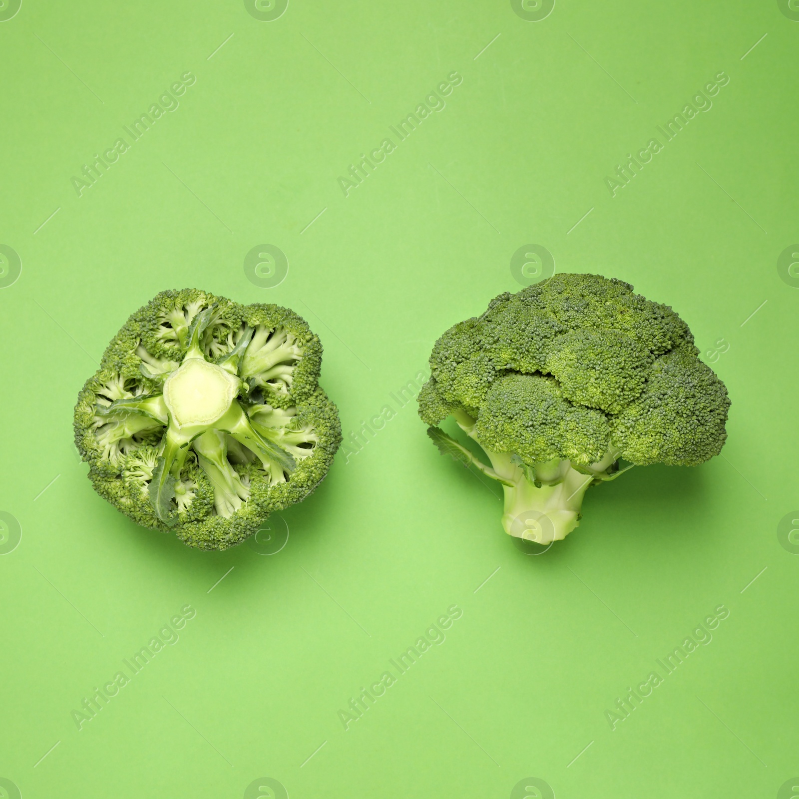 Photo of Fresh broccoli on green background, top view