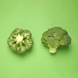 Photo of Fresh broccoli on green background, top view