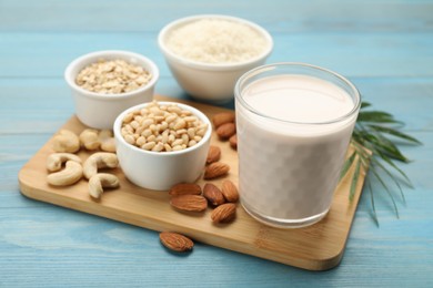 Photo of Vegan milk and ingredients on light blue wooden table, closeup