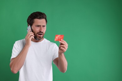Photo of Emotional man with credit card talking on phone against green background, space for text. Be careful - fraud