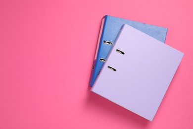 Photo of Office folders on pink background, flat lay. Space for text