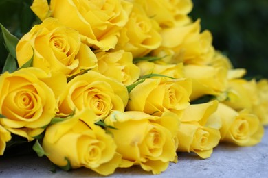 Photo of Beautiful bouquet of yellow roses on light table, closeup