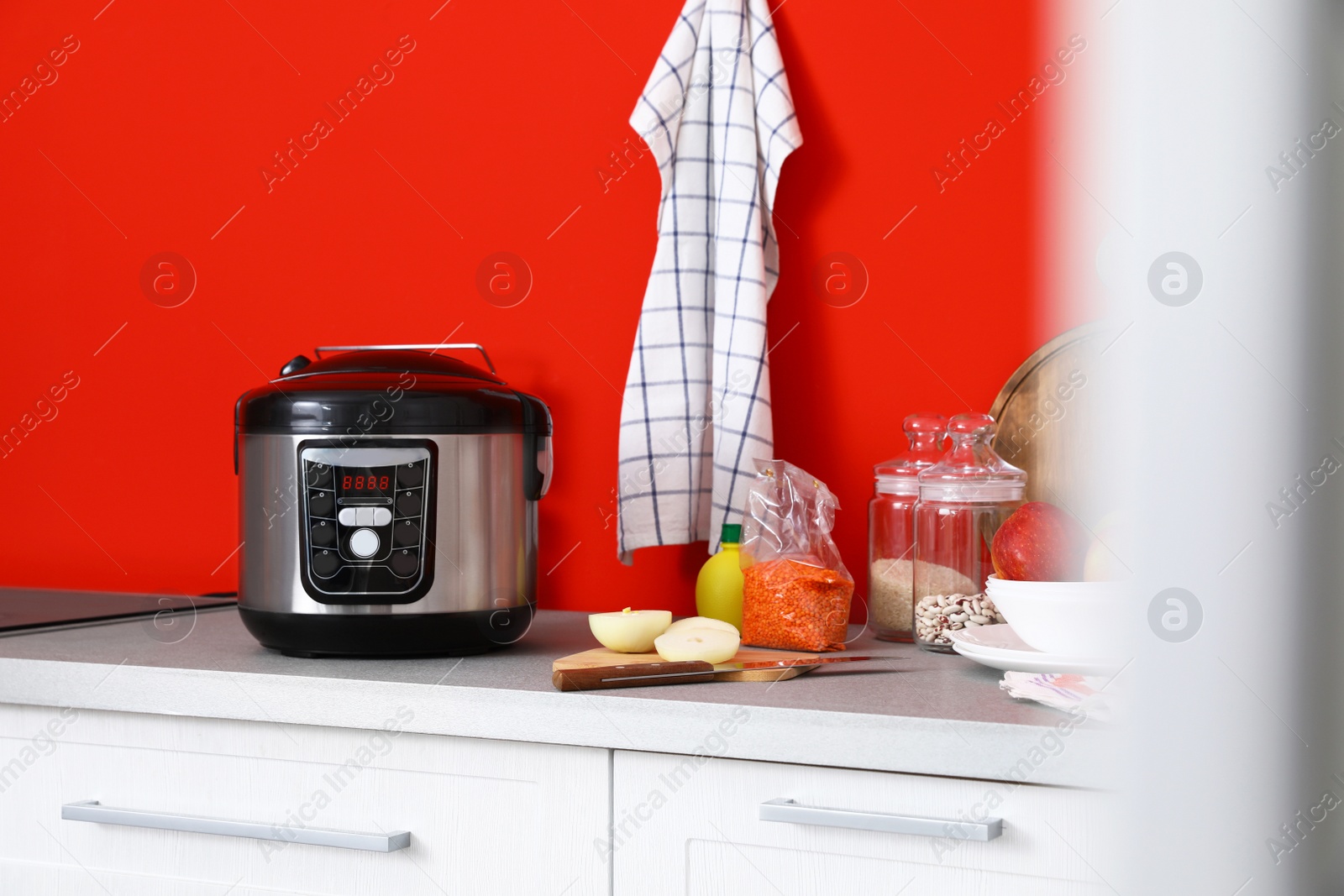 Photo of New modern multi cooker and products on table in kitchen