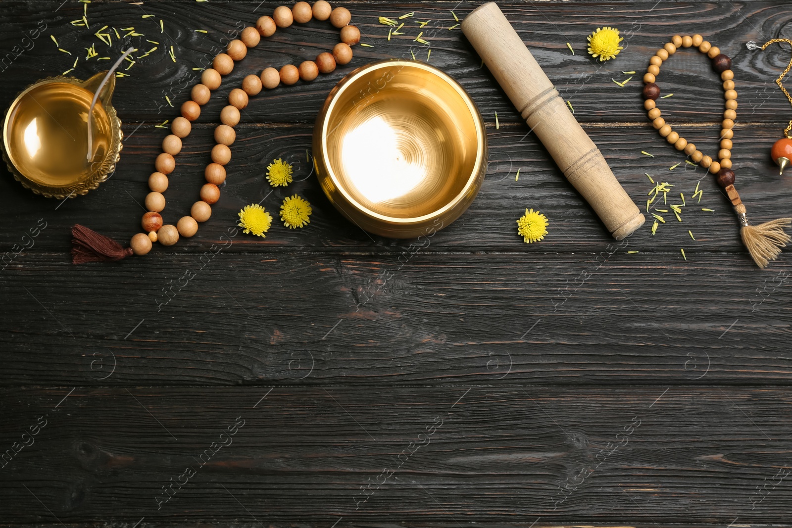 Photo of Flat lay composition with golden singing bowl on black wooden table, space for text. Sound healing