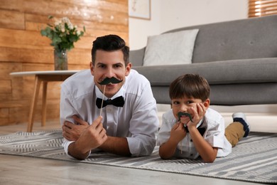 Photo of Dad and his son having fun at home. Happy Father's Day