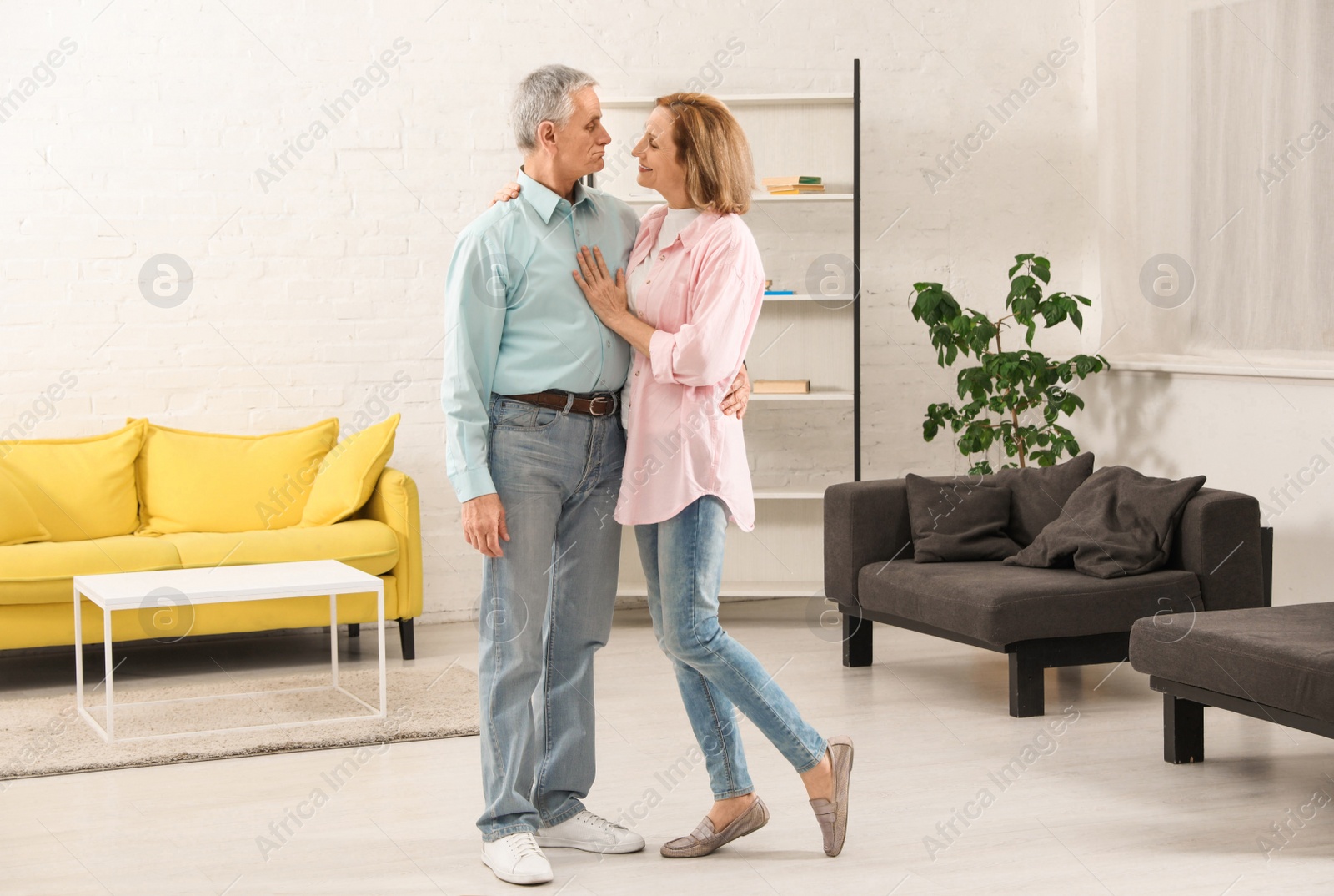 Photo of Happy senior couple dancing together in living room