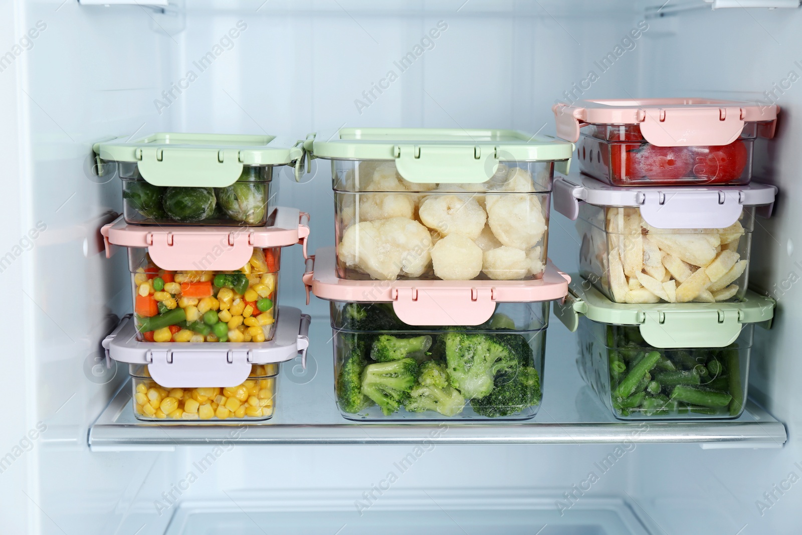 Photo of Containers with different frozen vegetables in refrigerator