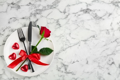 Photo of Beautiful table setting on white marble background, top view with space for text. Valentine's Day dinner