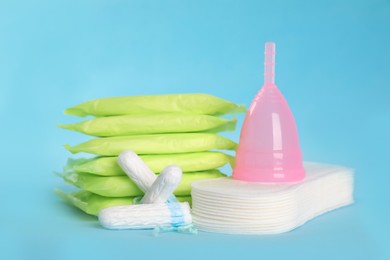 Photo of Menstrual pads and other hygiene products on light blue background