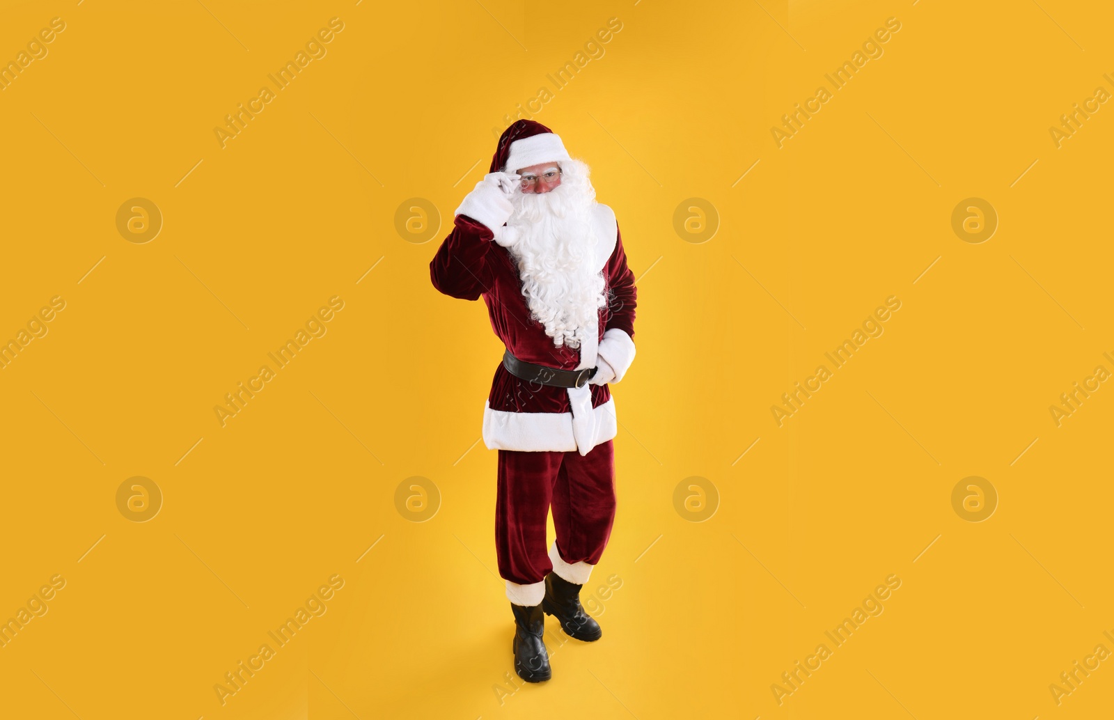 Photo of Full length portrait of Santa Claus on yellow background