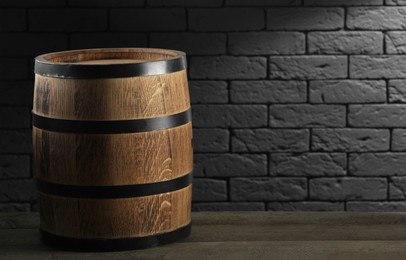 One wooden barrel on table near brick wall. Space for text