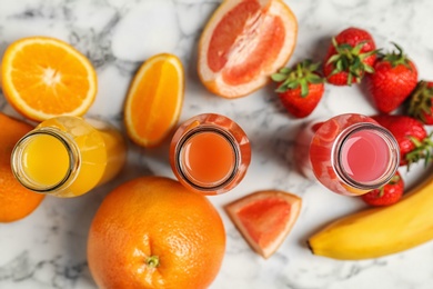 Photo of Flat lay composition with tasty juices and ingredients on marble background