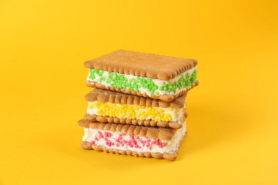 Photo of Sweet delicious ice cream cookie sandwiches on yellow background