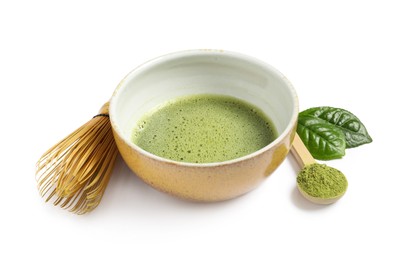 Photo of Cup of fresh matcha tea, spoon with green powder and bamboo whisk isolated on white