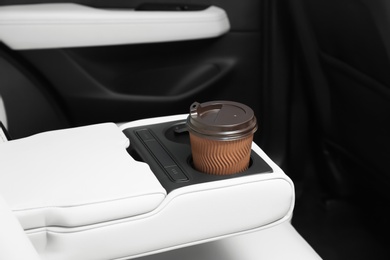 Photo of Takeaway paper coffee cup in holder inside car