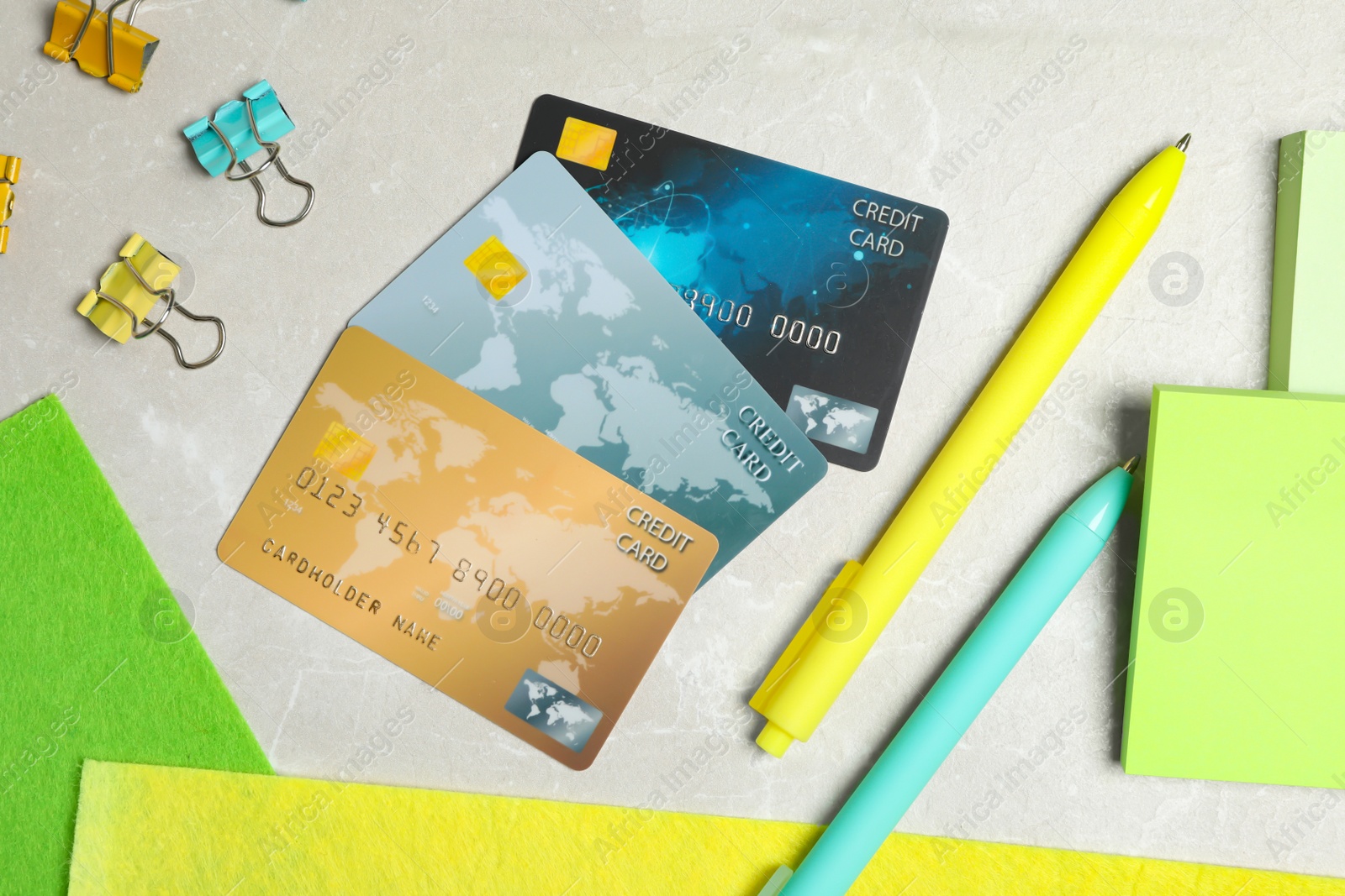 Photo of Flat lay composition with credit cards and stationery on light grey marble background