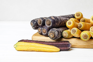 Photo of Many different raw carrots on white wooden table, closeup