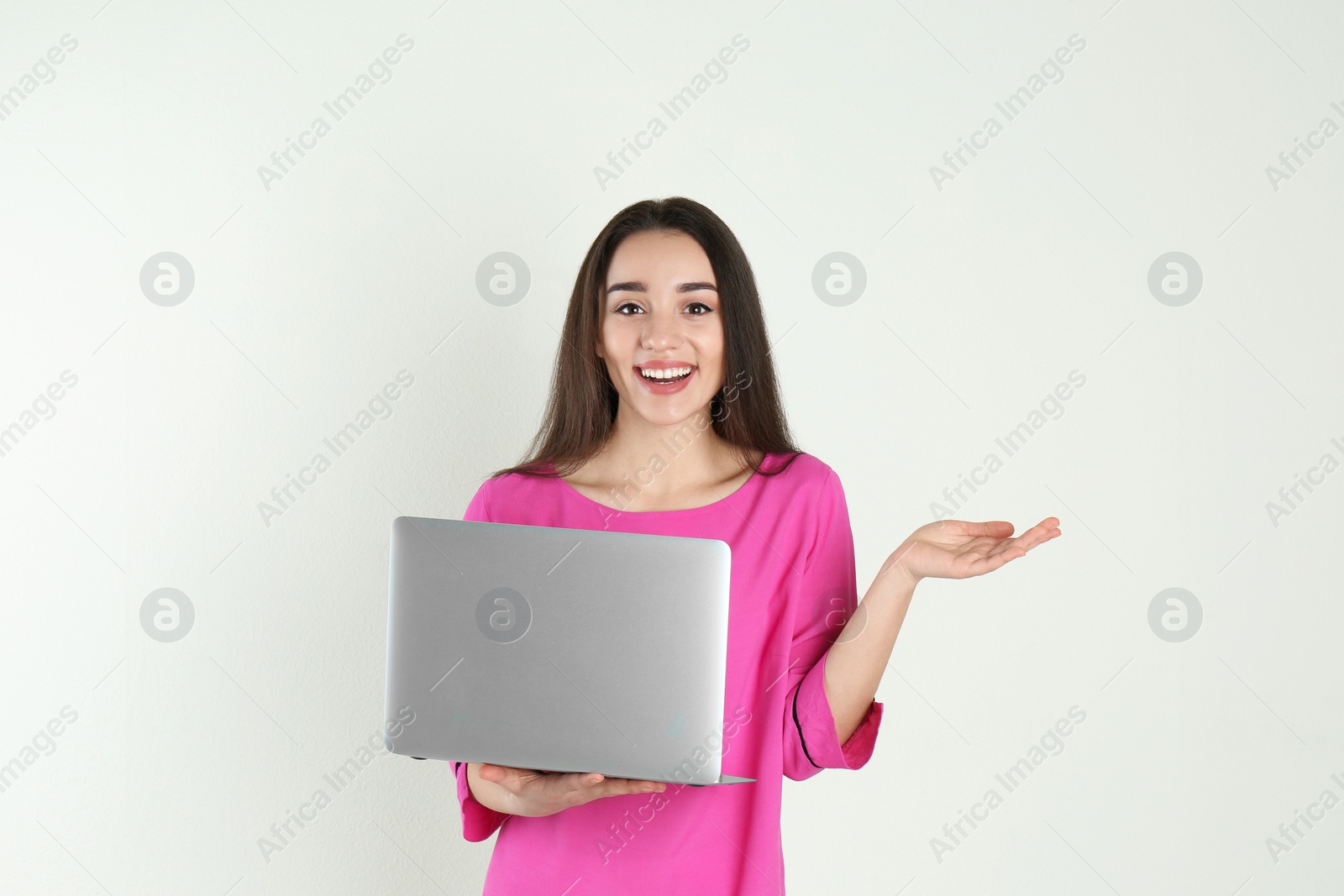 Photo of Portrait of young woman in casual outfit with laptop on light background