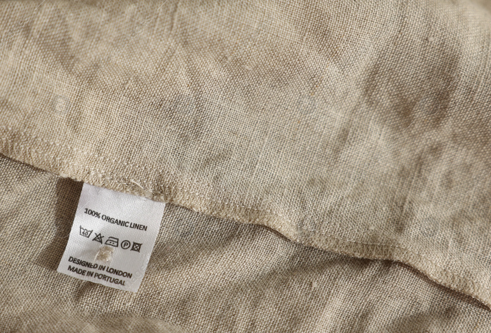 Photo of Clothing label on beige garment, closeup view