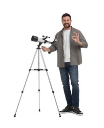 Happy astronomer with telescope showing ok gesture on white background