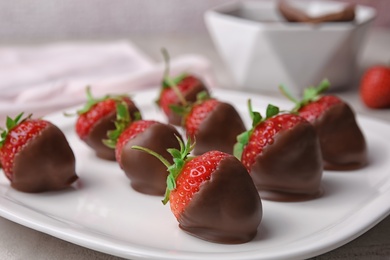 Photo of Plate with chocolate covered strawberries on table, closeup