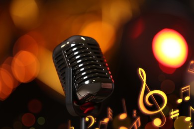 Image of Retro microphone, music notes and other musical symbols against festive lights, closeup