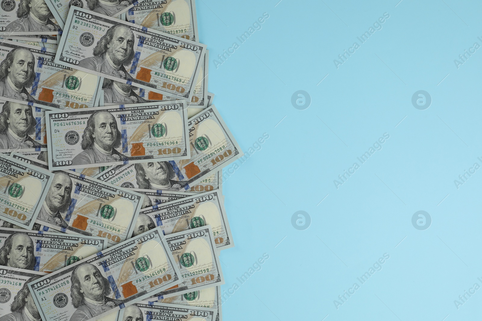 Photo of Money exchange. Dollar banknotes on light blue background, top view. Space for text