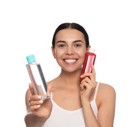 Photo of Young woman with bottles of micellar water on white background