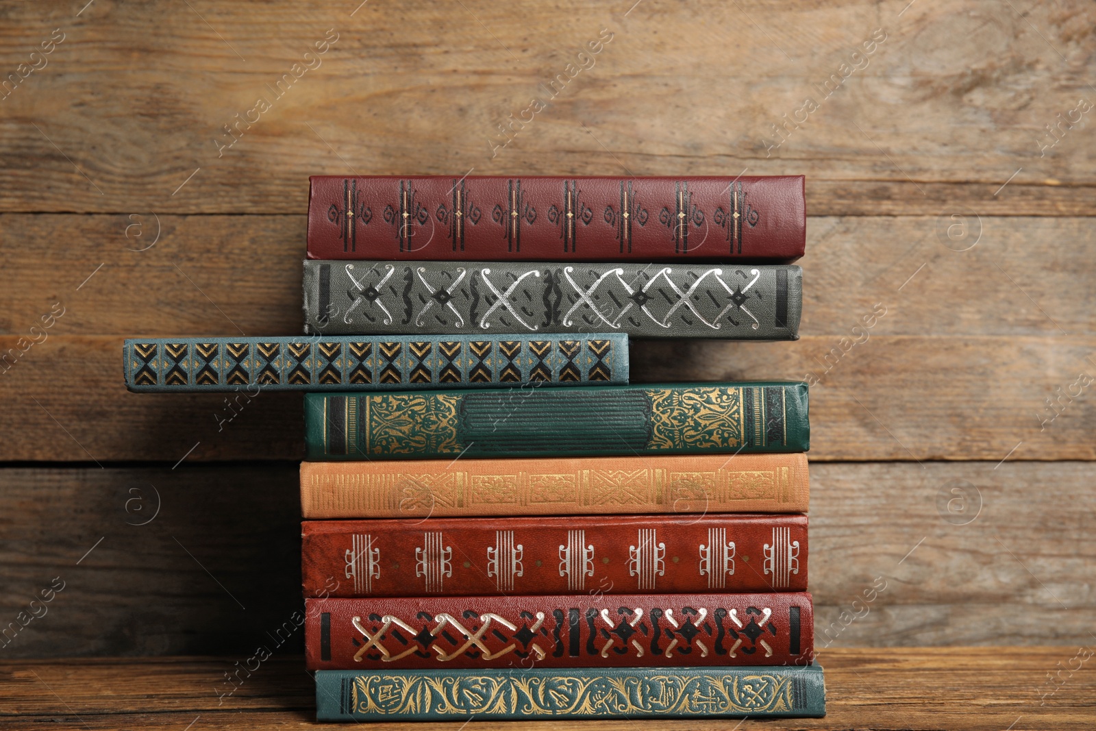 Photo of Collection of different books on table against wooden background