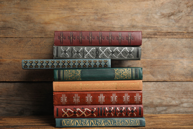 Collection of different books on table against wooden background