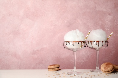 Photo of Cotton candy served in cocktail glasses on table. Space for text