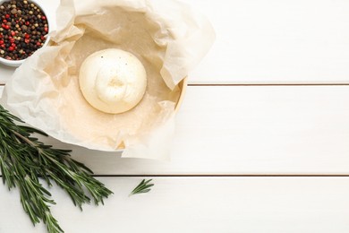 Photo of Delicious burrata cheese with rosemary and peppercorns on white wooden table, flat lay. Space for text