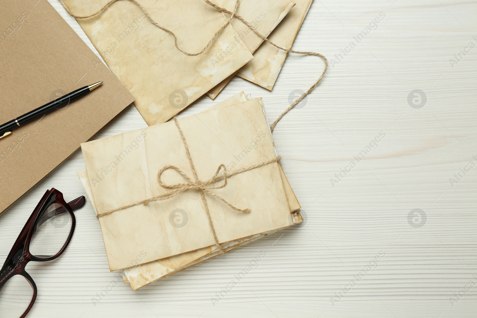 Photo of Old letters and glasses on white wooden table, flat lay. Space for text