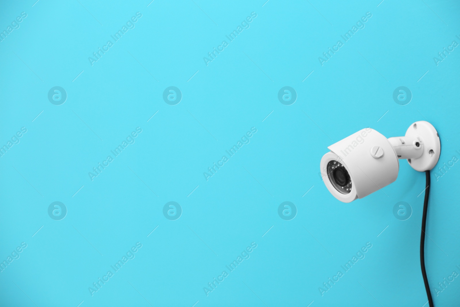 Photo of Modern security CCTV camera on color wall