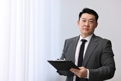 Photo of Portrait of confident notary with clipboard indoors, space for text