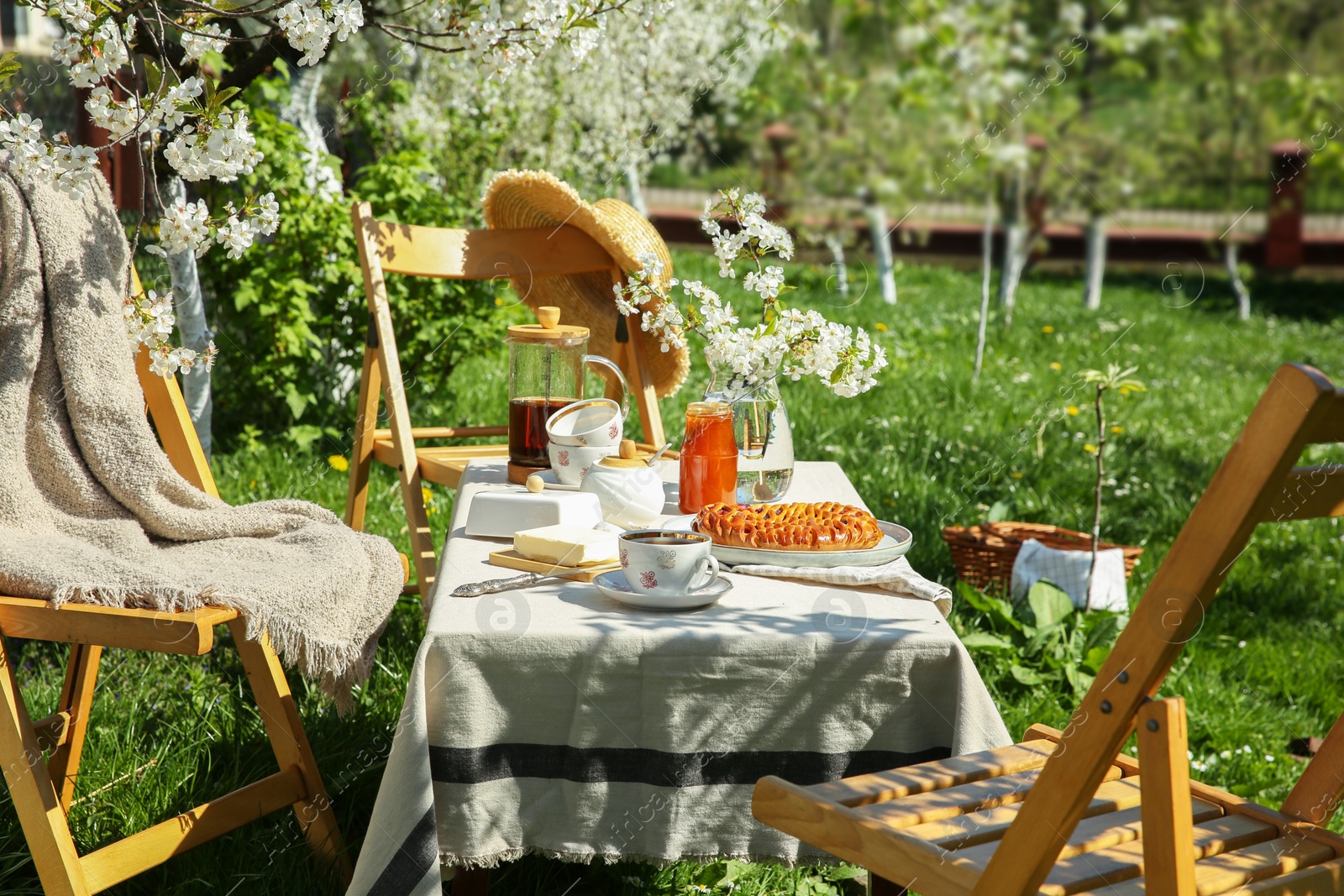 Photo of Beautiful table setting with spring flowers in garden on sunny day