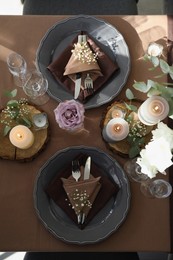 Festive table setting with beautiful tableware, candles and floral decor indoors, top view