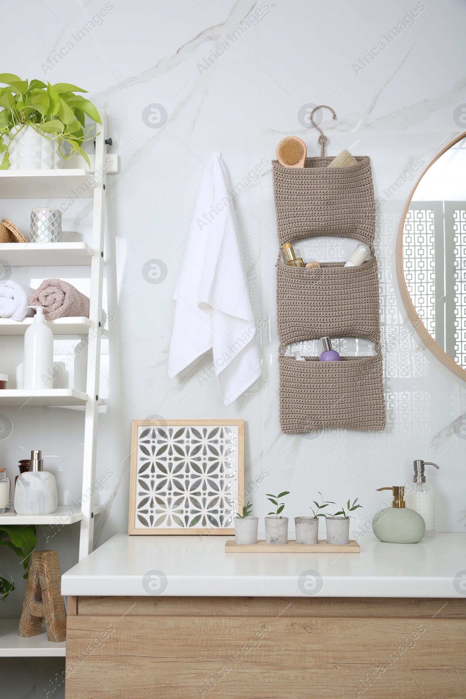 Photo of Knitted organizer hanging on wall in bathroom